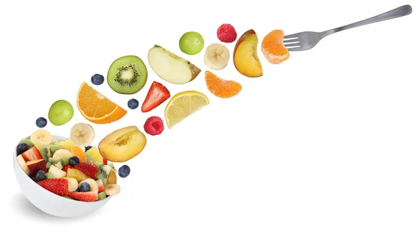 Съедая летающий фруктовый салат с вилкой, фруктами как яблоки, апельсины — стоковое фото
