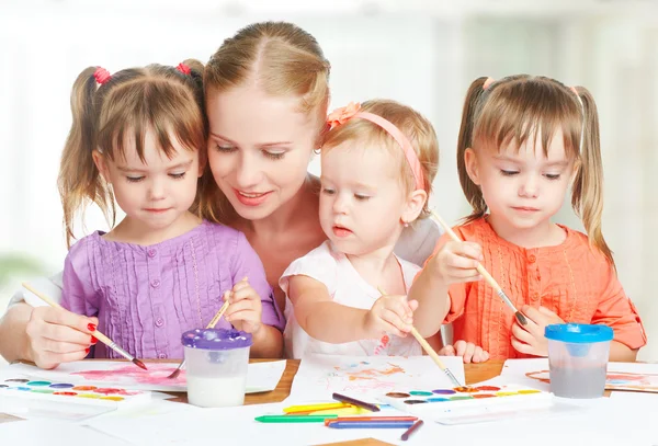 Сестры-близнецы детей рисовать краски с матерью в детском саду — стоковое фото