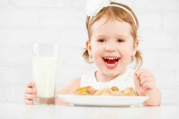 Счастливый ребенок девочка ест печенье и молоко — стоковое фото