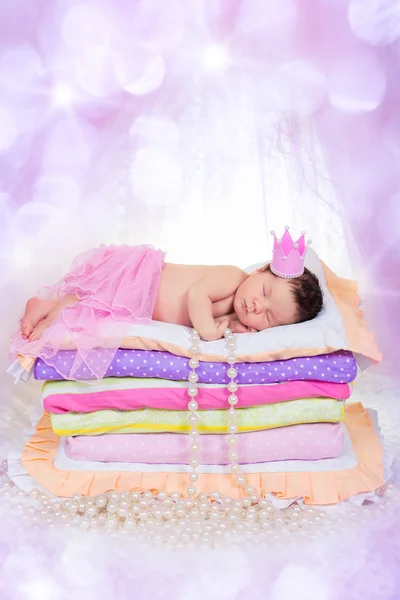 Новорожденный ребенок девочка в короне, на кровати матрасы. Фея Принцесса на горошине — стоковое фото