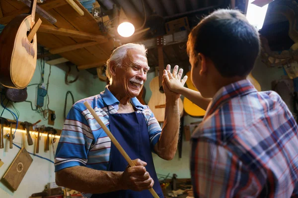 Старший мужчина лютня чайник преподавания мальчик обрубке древесины — стоковое фото
