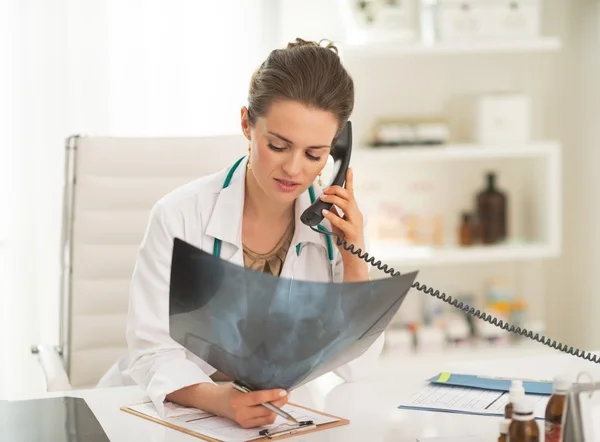 Женщина врач с флюорография, говоря телефон — стоковое фото