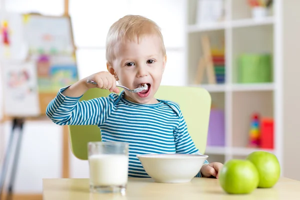 Ребенок ест здоровую пищу дома или сада — стоковое фото