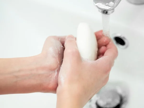 Мойка женские руки с мылом в ванной комнате — стоковое фото