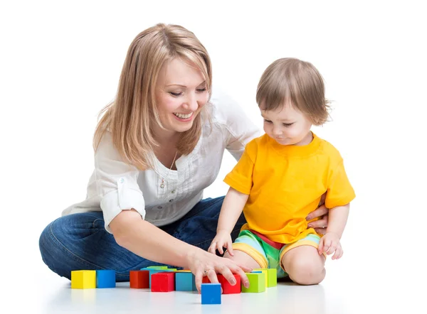 Мать и ребенок играть с игрушкой строительные блоки, изолированные на белом фоне — стоковое фото