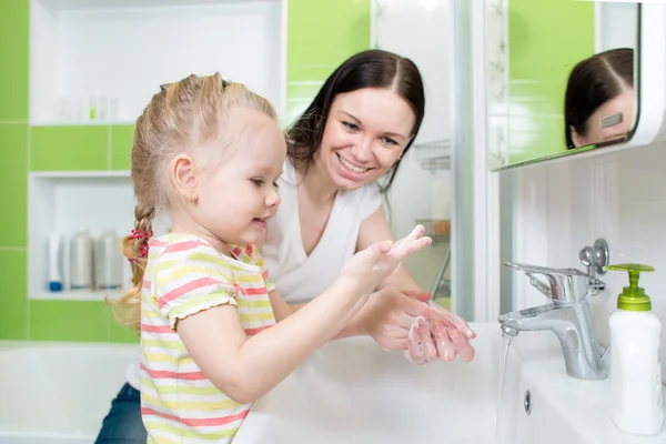 Счастливая мать и ребенок, мытье рук с мылом в ванной комнате — стоковое фото