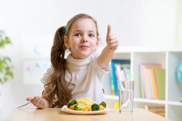 Ребенок ест здоровую пищу, показывает палец вверх — стоковое фото