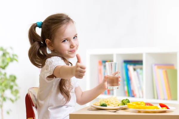 Ребенок ест здоровую пищу, показывает палец вверх — стоковое фото