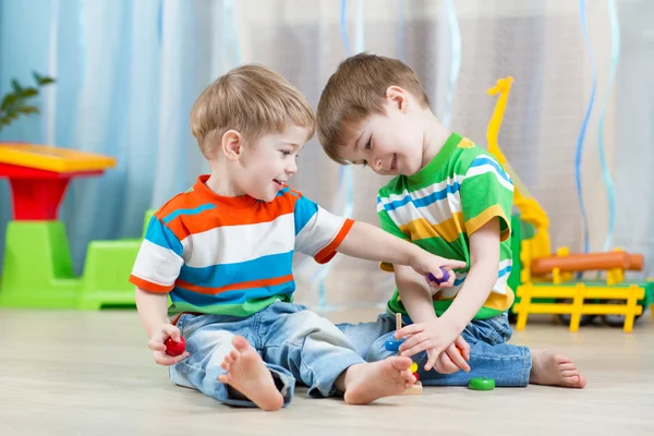 Дети братья играли вместе в детском саду или центре дневного ухода за детьми — стоковое фото