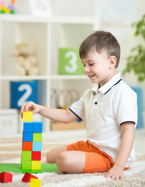 Ребенок мальчик, играя с деревянных красочных кубиков — стоковое фото
