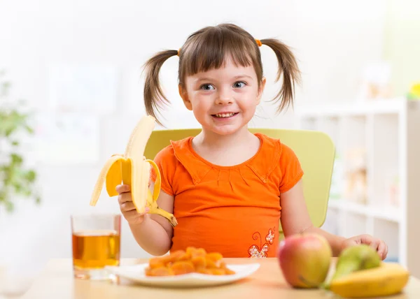 Употребление здоровой пищи дома ребенка — стоковое фото