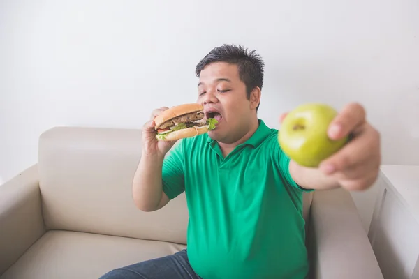 Человек любит нездоровую пищу лучше, чем здоровые свежие фрукты — стоковое фото