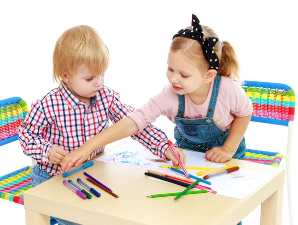 Мальчик и девочка, рисование карандашами, сидя за столом — стоковое фото