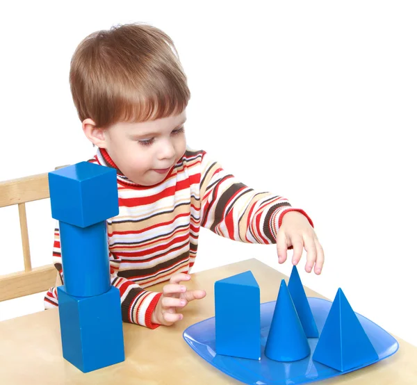 Маленький мальчик играет кубов и конусов, сидя за столом, Montessor — стоковое фото