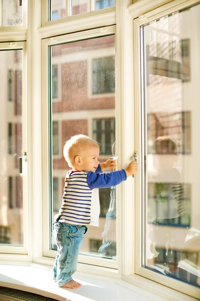 Маленький мальчик, глядя на окна — стоковое фото