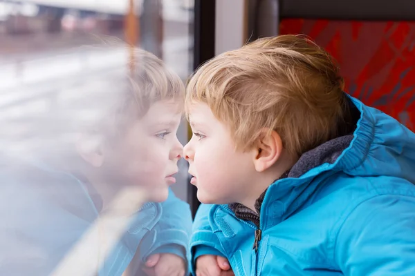 Милый ребенок, путешествующий и наблюдение, обучают окно снаружи — стоковое фото