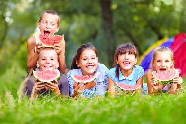 Группа счастливые дети едят арбузы — стоковое фото