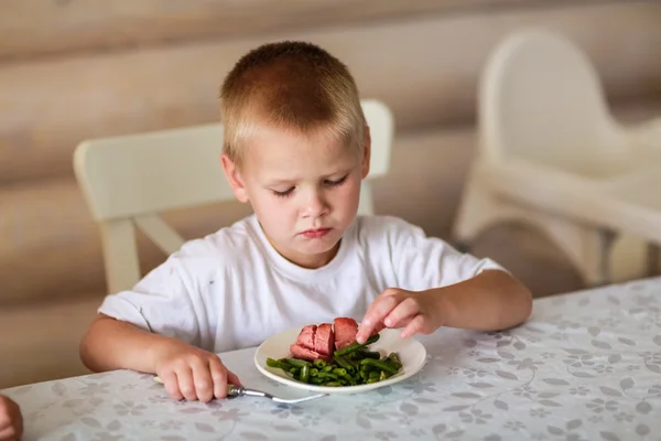 Ребенок ест за столом — стоковое фото