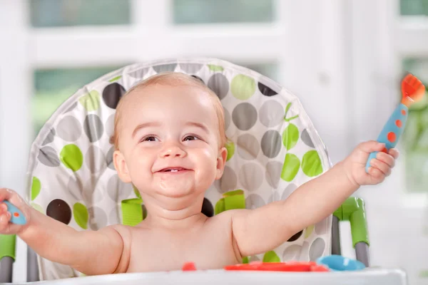 Счастливый ребенок ест себя с ложкой и вилкой — стоковое фото
