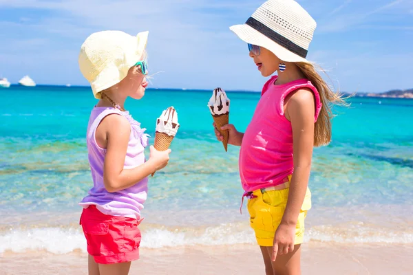 Очаровательные девочки едят мороженое на тропическом пляже — стоковое фото