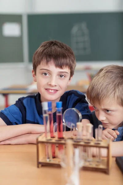 Two young boys in chemistry class — стоковое фото