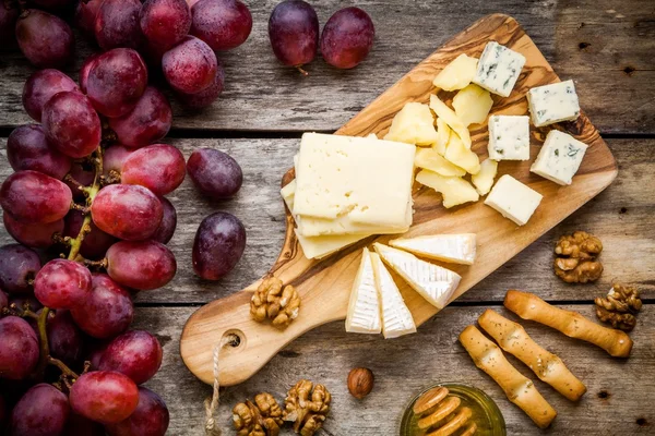 Сырное: Эмменталь, сыр камамбер, голубой сыр, хлеб, палочки, грецкие орехи, лещинные орехи, мед, виноград — стоковое фото