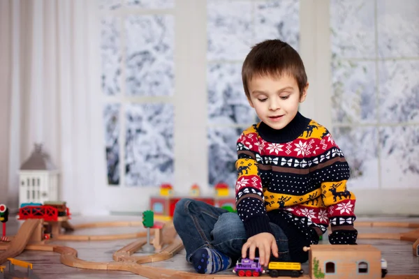 Очаровательны мало дошкольного возраста мальчик, играя с деревянными поезда и РА — стоковое фото