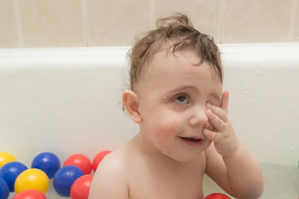 Ребенок в ванной с цветными шарами — стоковое фото