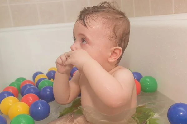 Ребенок в ванной с цветными шарами — стоковое фото