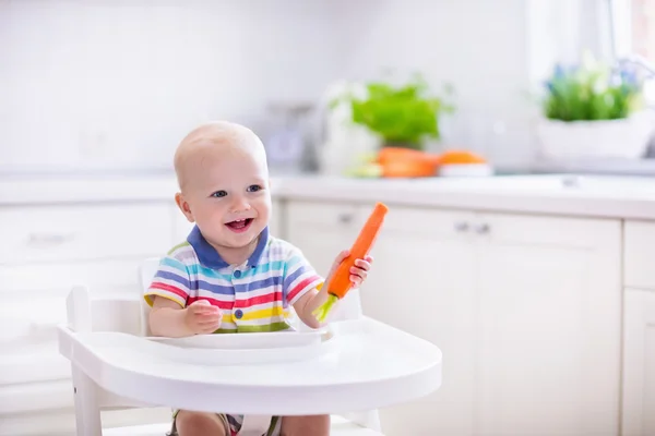 Маленький ребенок ест морковь — стоковое фото