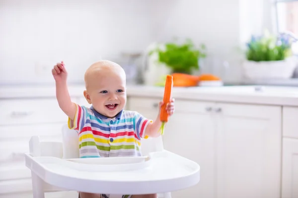 Маленький ребенок ест морковь — стоковое фото
