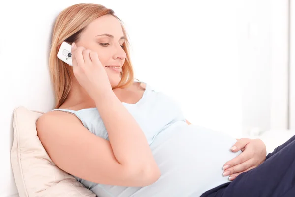 Беременная женщина, говоря на мобильный телефон — стоковое фото
