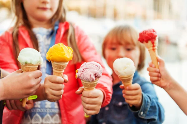 5 corns of colorful ice cream holding by kids — стоковое фото