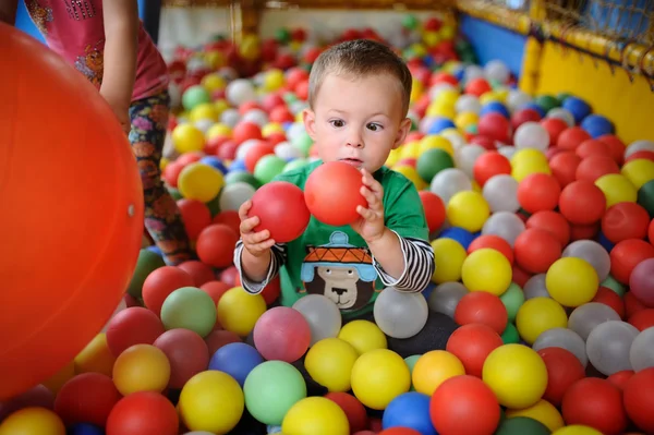 Мальчик смотрит с удивлением на цветные шары. squin ребенка — стоковое фото