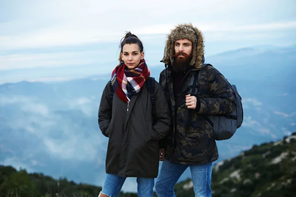 Пара молодых туристов, стоя на вершине горы в прохладный осенний день — стоковое фото