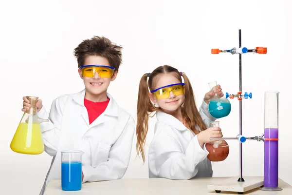 Две милые дети на уроке химии, делая эксперименты — стоковое фото