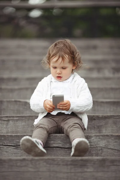 Маленькая девочка, играя с мобильного телефона — стоковое фото
