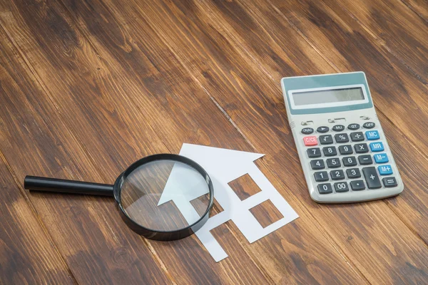 Купить дом ипотечного расчетов, калькулятор с лупой — стоковое фото