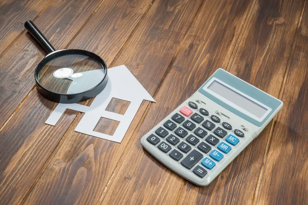 Купить дом ипотечного расчетов, калькулятор с лупой — стоковое фото