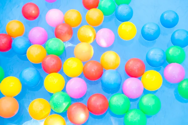 Цветные шарики, плавающие в бассейн для малышей — стоковое фото