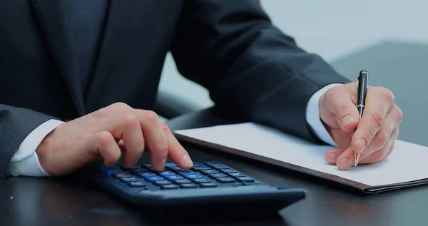Бизнесмен использует калькулятор для расчетов — стоковое фото