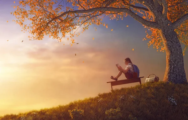 Ребенок, читая книгу возле дерева — стоковое фото