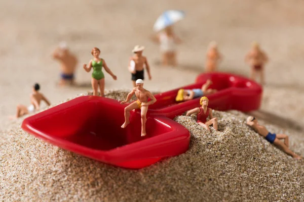 Миниатюрные люди в купальнике на пляже — стоковое фото