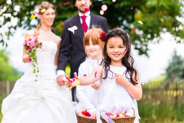 Свадебная пара и невесты поливать цветы — стоковое фото