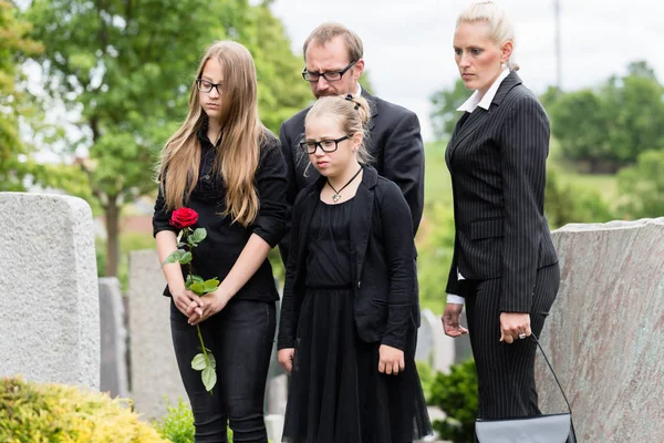Семья на кладбище, оплакивая покойного относительной — стоковое фото