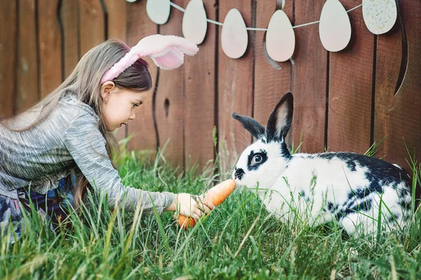 Девочка кормит кролик с морковкой — стоковое фото