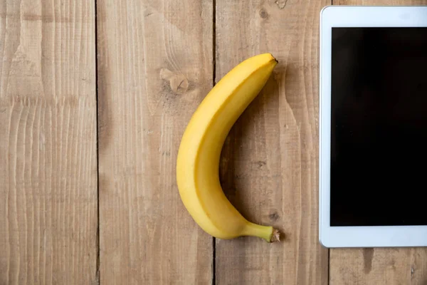 Банан и цифровой планшет — стоковое фото