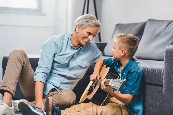 Дед и внук, играть на гитаре — стоковое фото