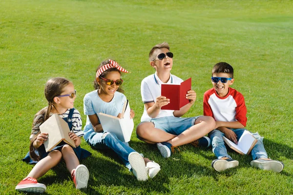Дети, читать книги в парке — стоковое фото