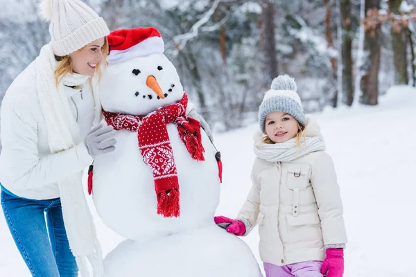 Красивые Счастливые Мать Дочь Стоя Снеговика Зимнем Парке — стоковое фото